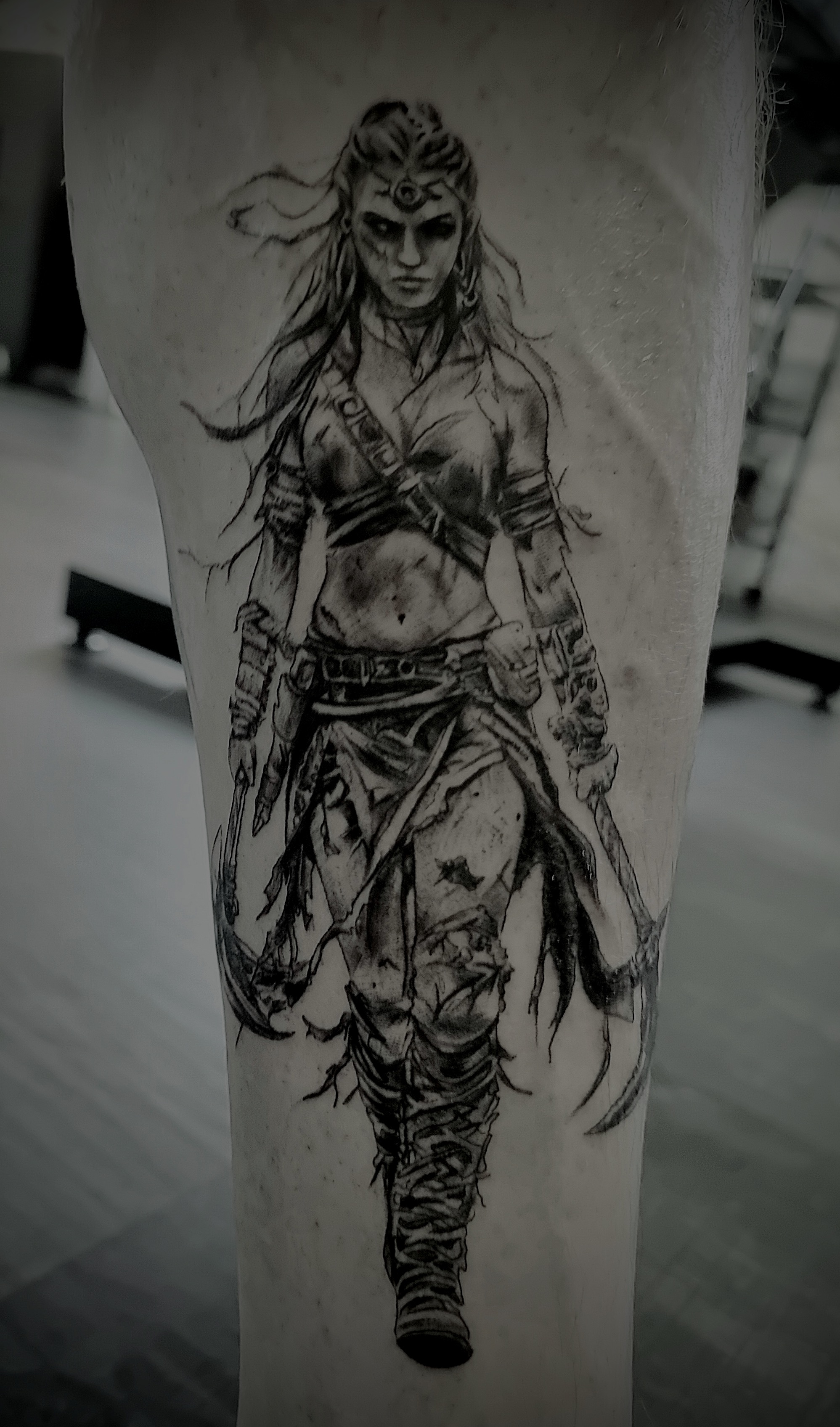 Tattoo einer entschlossenen Kriegerin mit drittem Auge in Schwarz auf Bein
