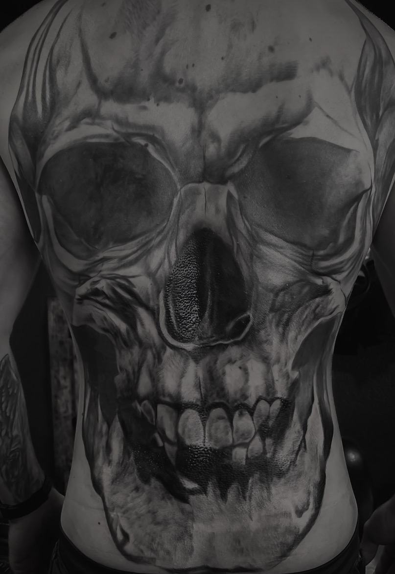 Grosses realistisches Totenkopf Tattoo in Schwarz auf einem Ruecken
